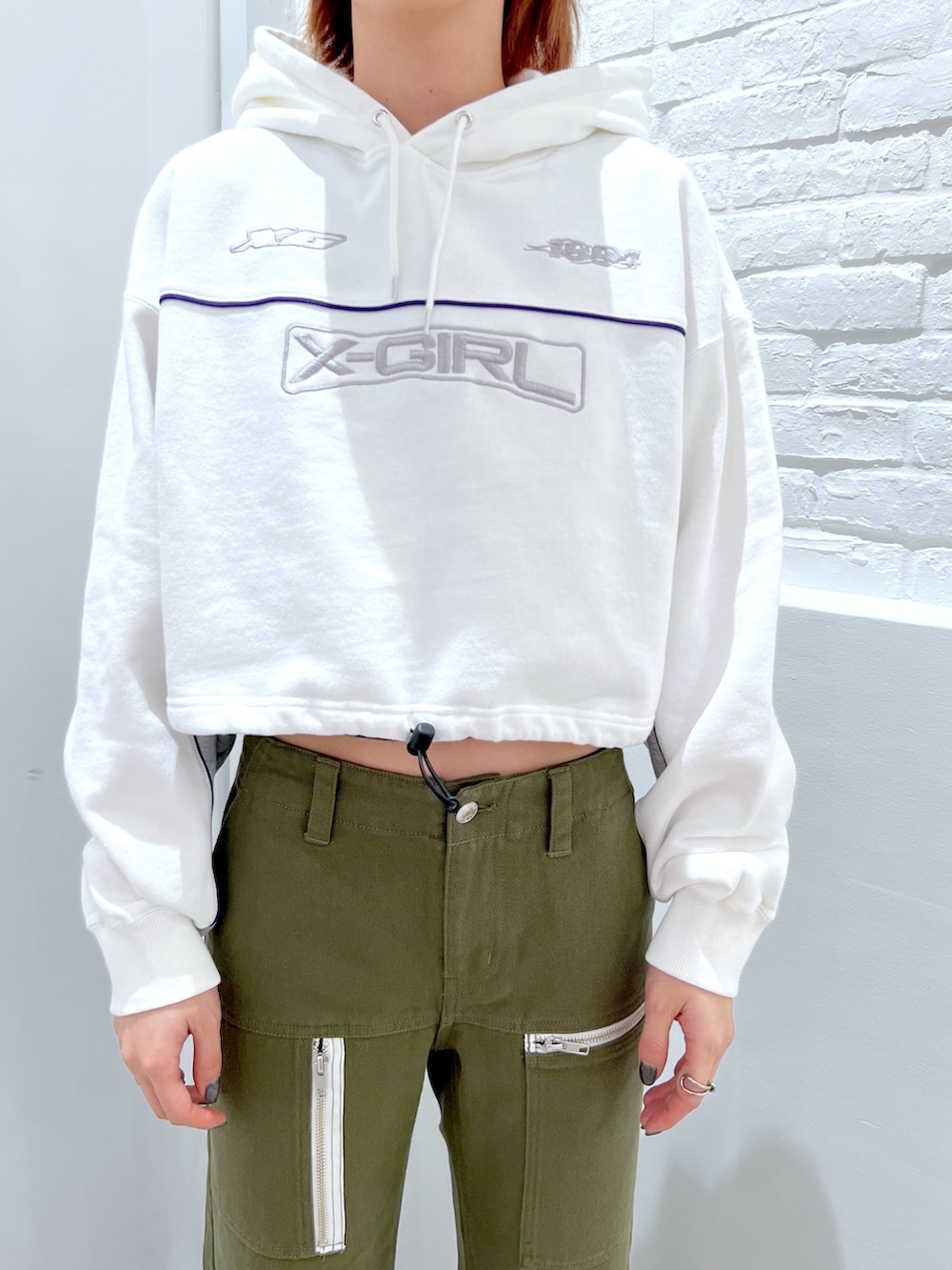 グリーン系のその他パンツ、ホワイト系のパーカー、ブラック系のバックパック/リュックを着用したレディースの冬コーディネートの4枚目の写真