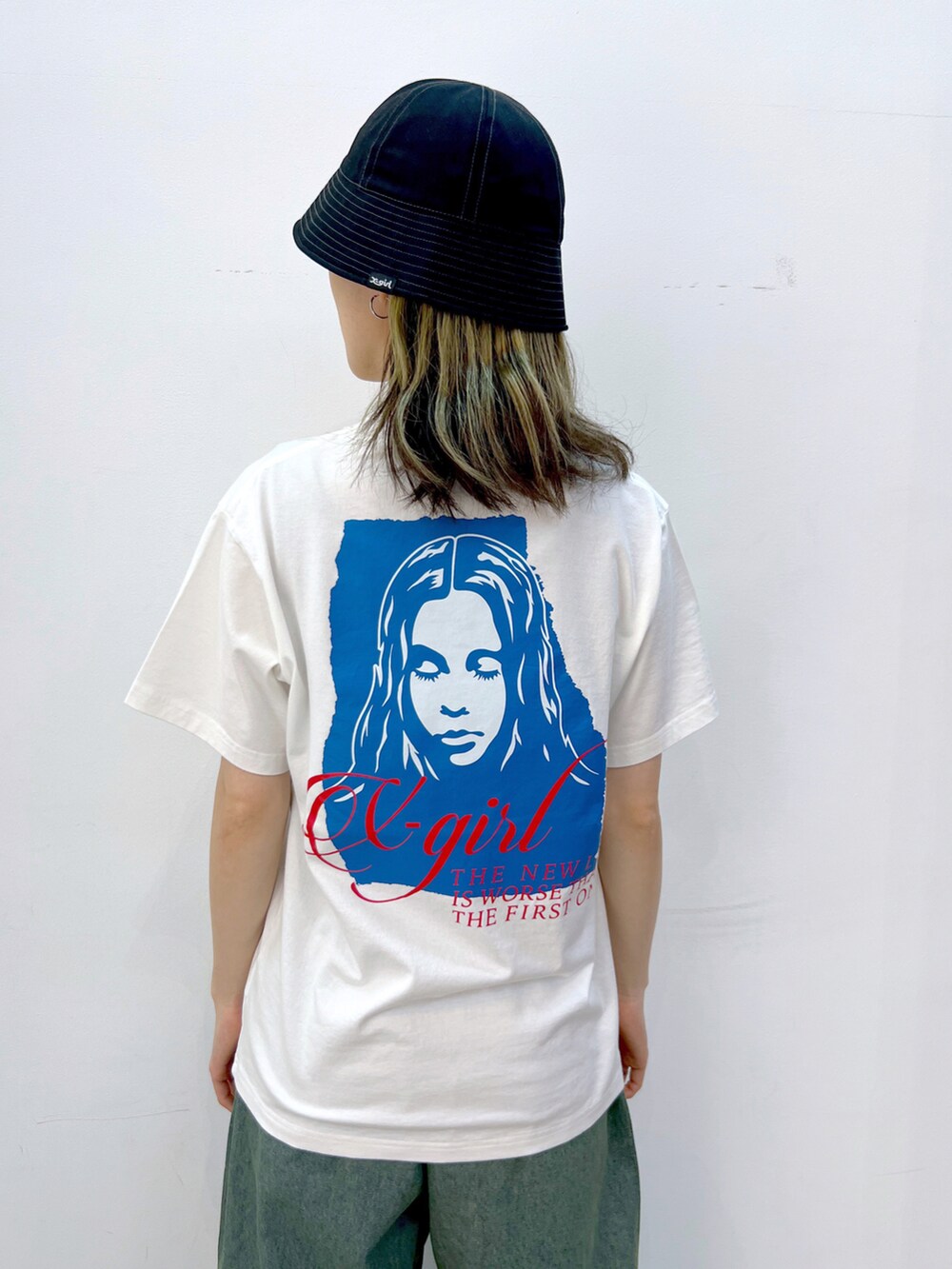 ブルー系のデニムパンツ、ホワイト系のTシャツ/カットソー、ブラック系のハットを着用したレディースの夏コーディネートの3枚目の写真