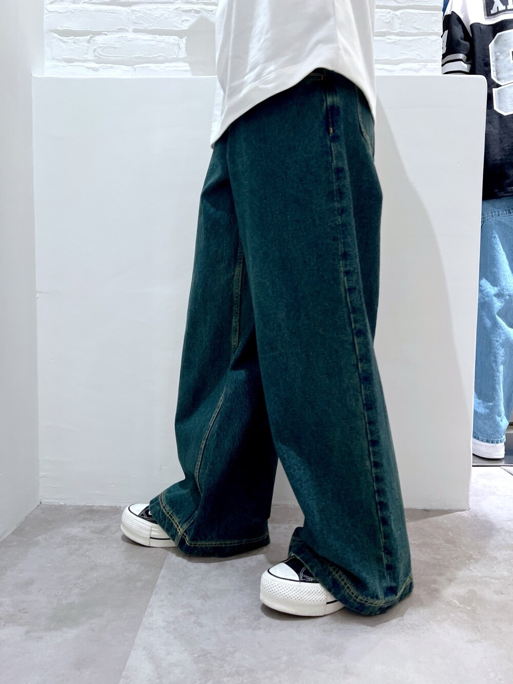 ブルー系のデニムパンツ、ホワイト系のTシャツ/カットソー、ベージュ系のハットを着用したレディースの春コーディネートの6枚目の写真