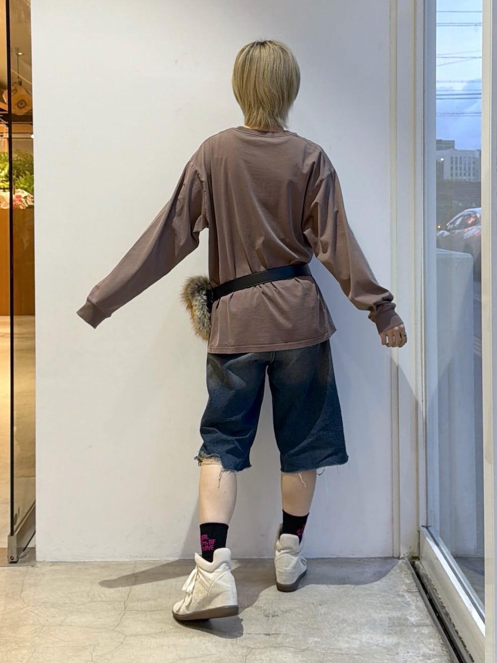 ブルー系のデニムパンツ、ブラウン系のワンピース、ブラック系のベルトを着用したレディースの秋コーディネートの2枚目の写真
