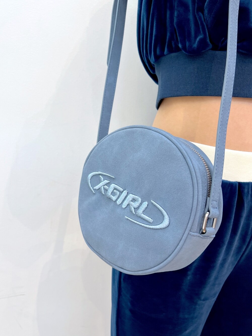 ブルー系のスウェット、ブルー系のその他パンツ、ブルー系のショルダーバッグを着用したレディースの秋コーディネートの5枚目の写真