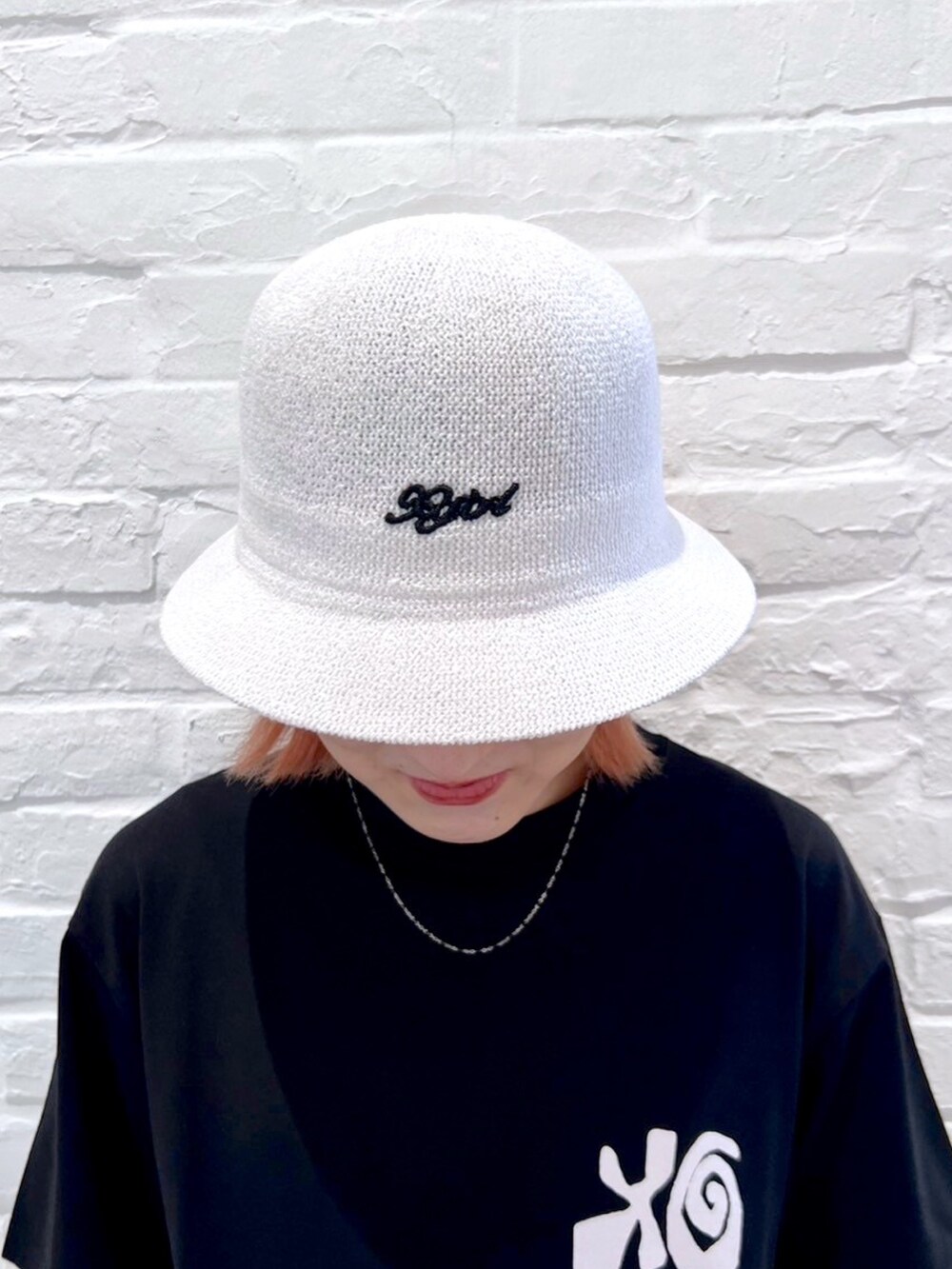 ブルー系のデニムパンツ、ブラック系のTシャツ/カットソー、ホワイト系のハットを着用したレディースの夏コーディネートの7枚目の写真