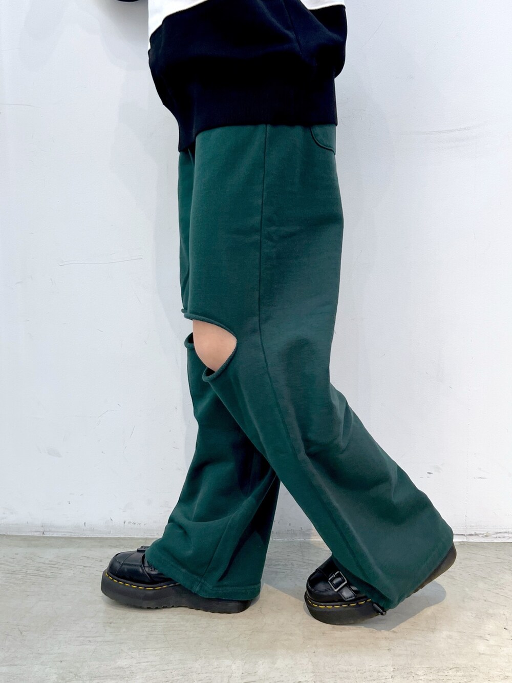 グリーン系のスウェットパンツ、ホワイト系のスウェット、ブラック系のキャップを着用したレディースの秋コーディネートの5枚目の写真