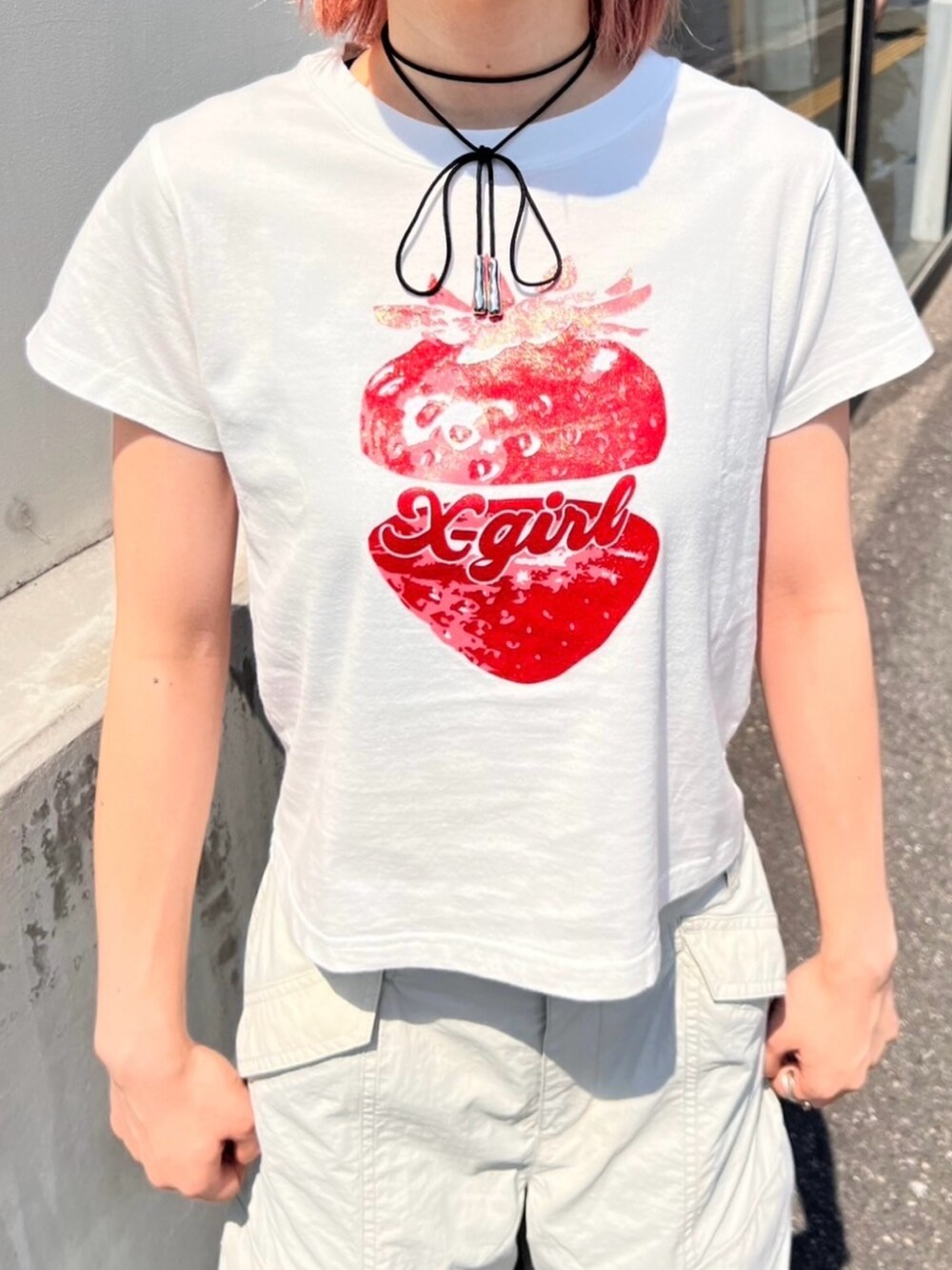 グレー系のカーゴパンツ、ホワイト系のTシャツ/カットソー、グレー系のキャップを着用したレディースの夏コーディネートの3枚目の写真