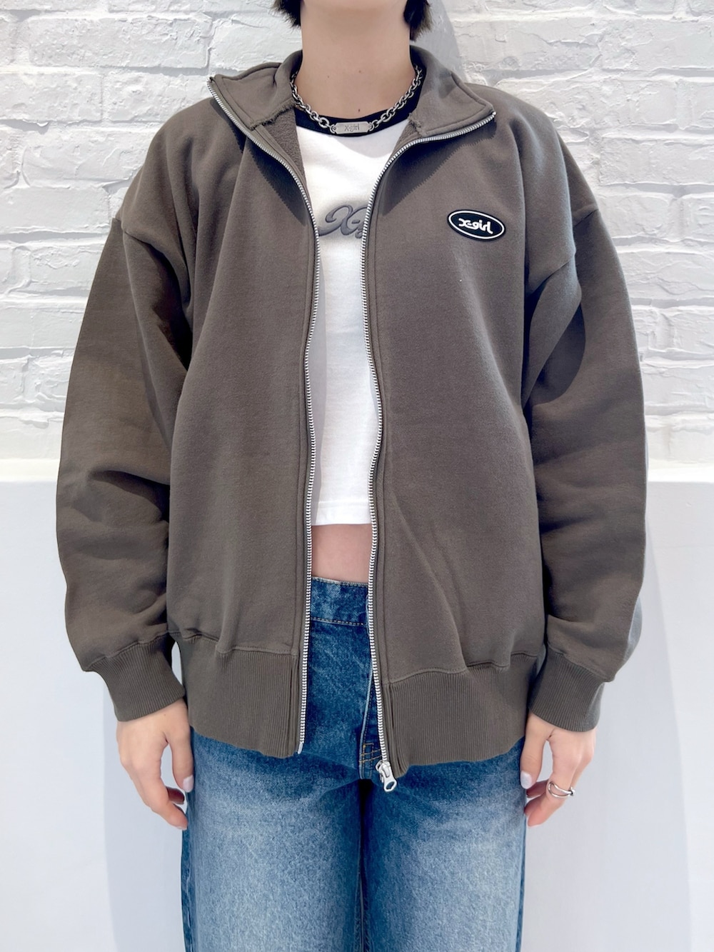 ブルー系のデニムパンツ、ホワイト系のTシャツ/カットソー、グリーン系のスウェットを着用したレディースの春コーディネートの3枚目の写真