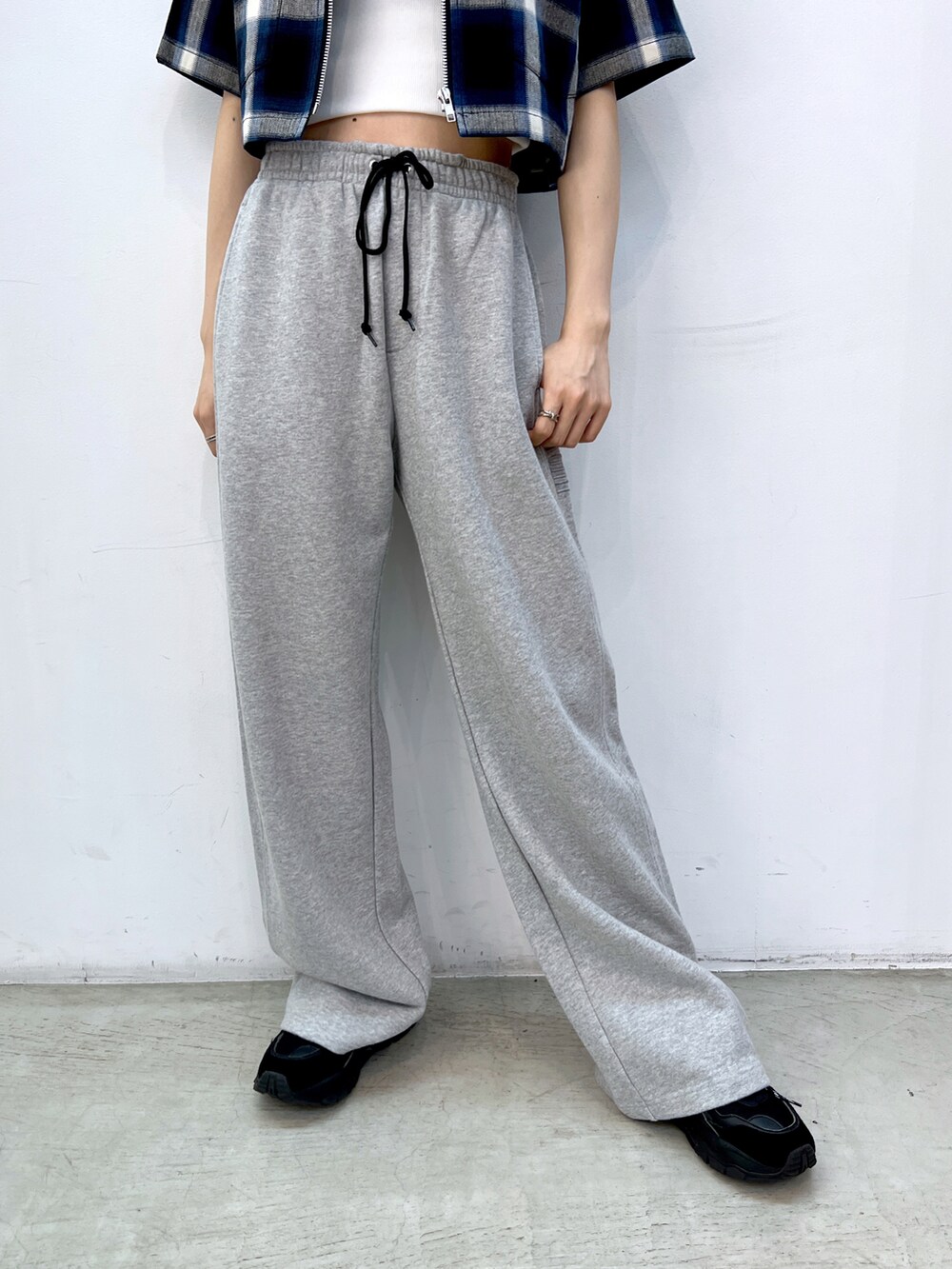 グレー系のスウェットパンツ、ブラック系のショルダーバッグ、ホワイト系のキャミソールを着用したレディースの夏コーディネートの4枚目の写真