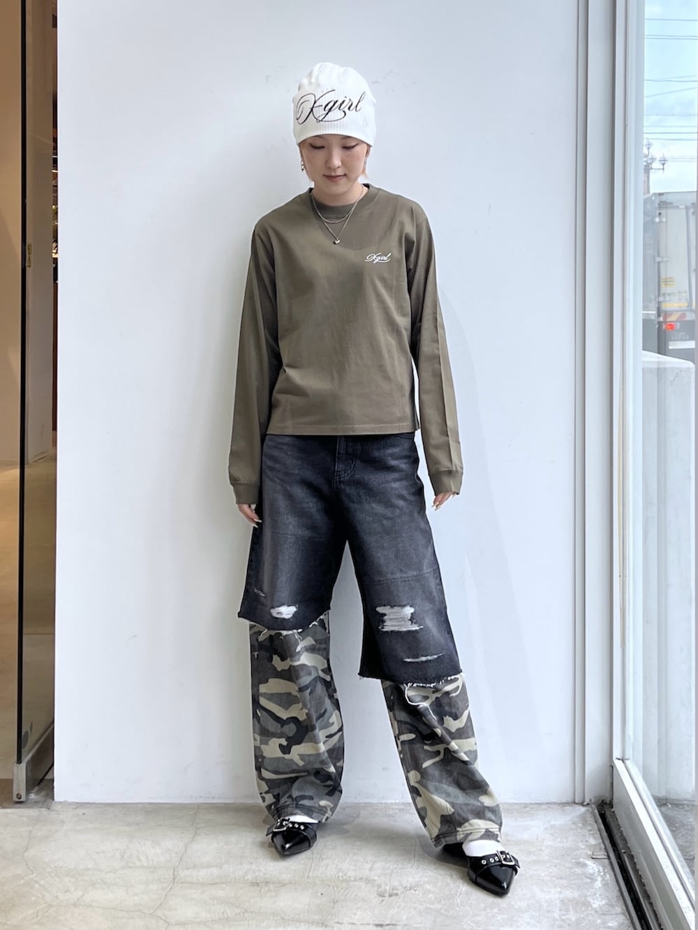 ブラック系のデニムパンツ、グリーン系のTシャツ/カットソー、ホワイト系のニットキャップ/ビーニーを着用したレディースの春コーディネートの2枚目の写真