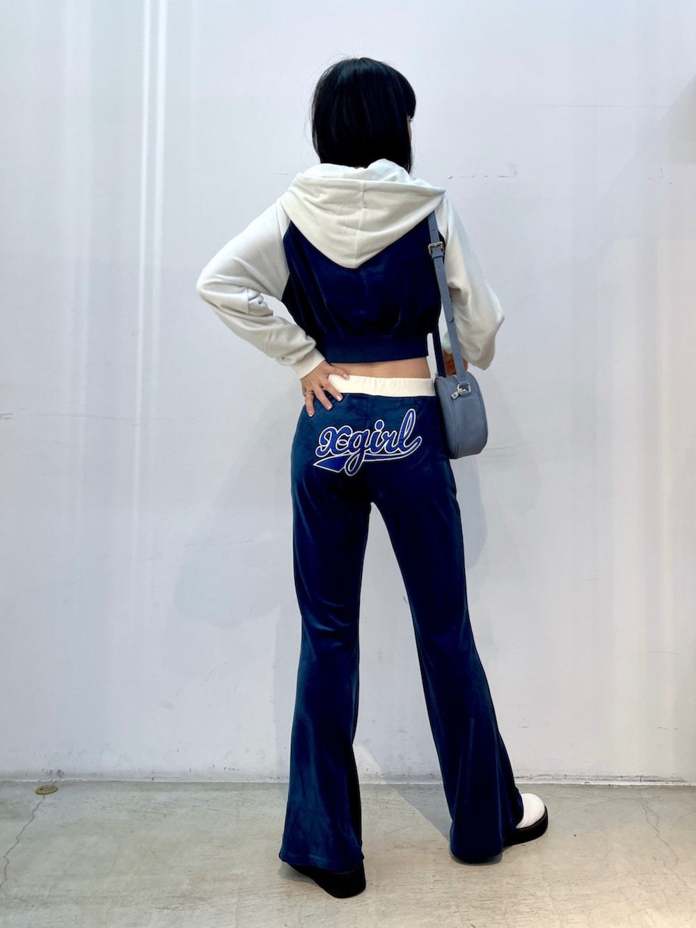 ブルー系のスウェット、ブルー系のその他パンツ、ブルー系のショルダーバッグを着用したレディースの秋コーディネートの2枚目の写真