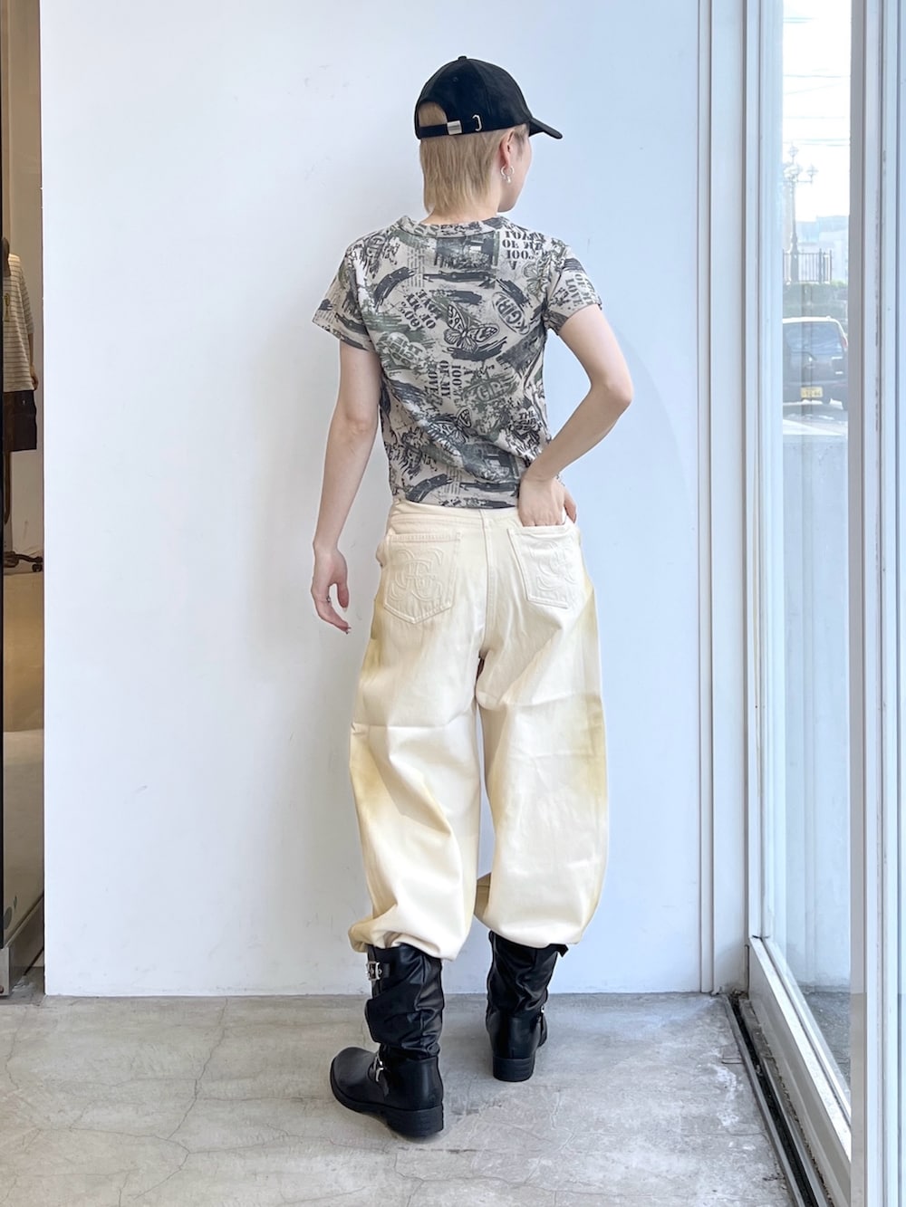 ホワイト系のデニムパンツ、ベージュ系のTシャツ/カットソー、ブラック系のキャップを着用したレディースの夏コーディネートの2枚目の写真
