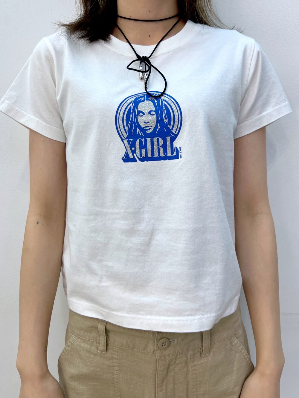 ベージュ系のその他パンツ、ブラック系のショルダーバッグ、ホワイト系のTシャツ/カットソーを着用したレディースの夏コーディネートの3枚目の写真