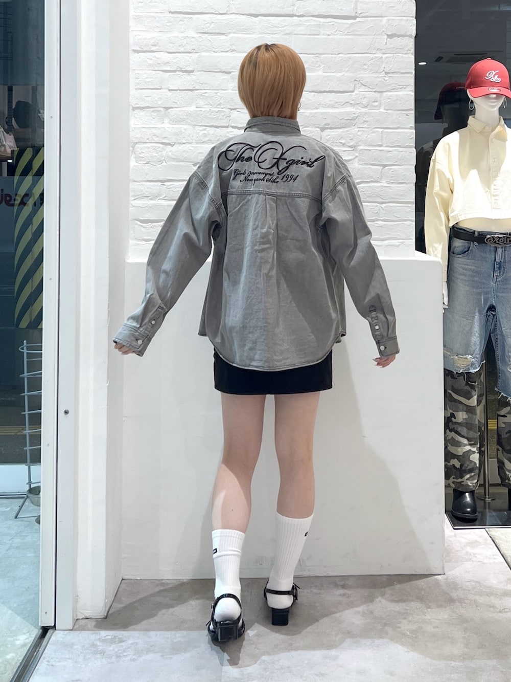 ブラック系のスカート、ホワイト系のTシャツ/カットソー、ブラック系のシャツ/ブラウスを着用したレディースの春コーディネートの2枚目の写真