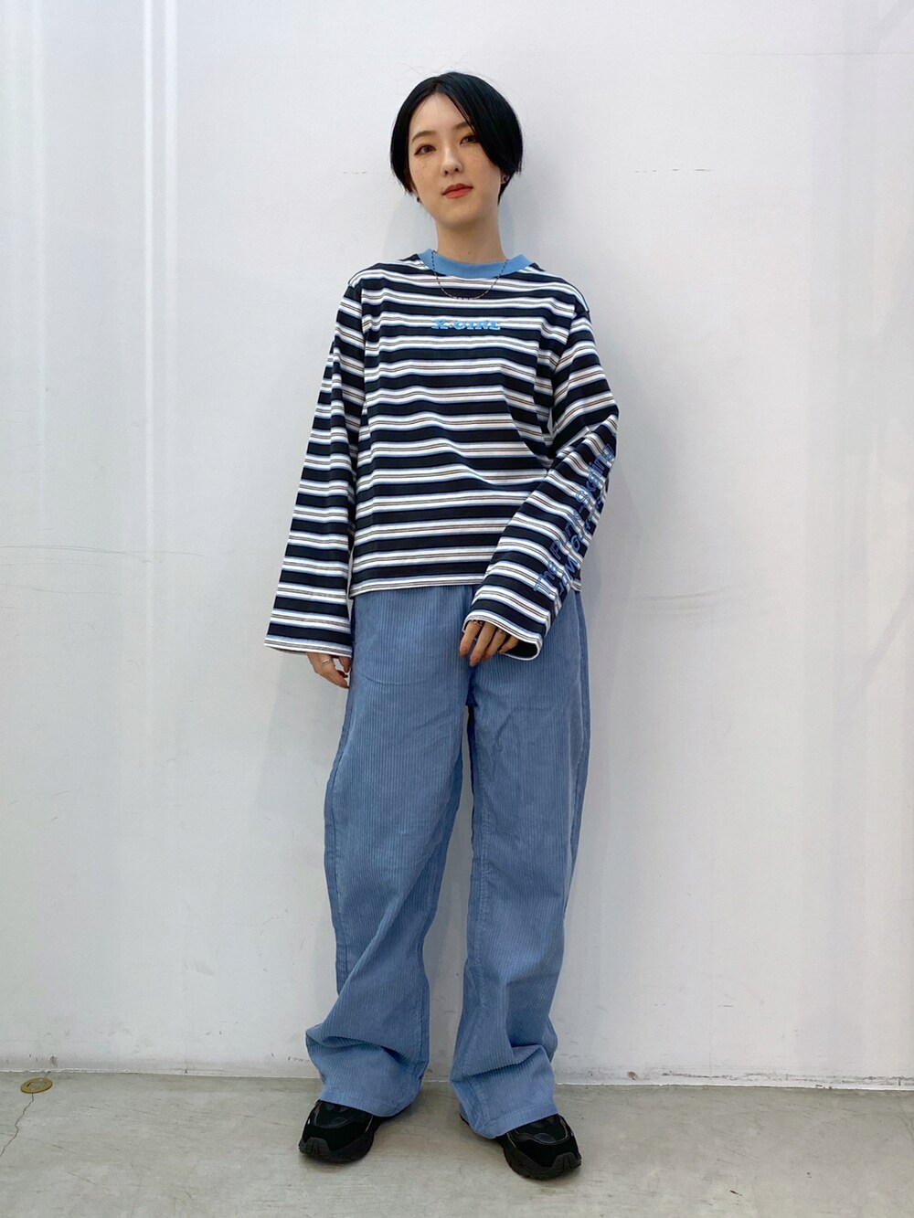 ブルー系のその他パンツ、グレー系のTシャツ/カットソー、ブラック系のショルダーバッグを着用したレディースの冬コーディネートの4枚目の写真