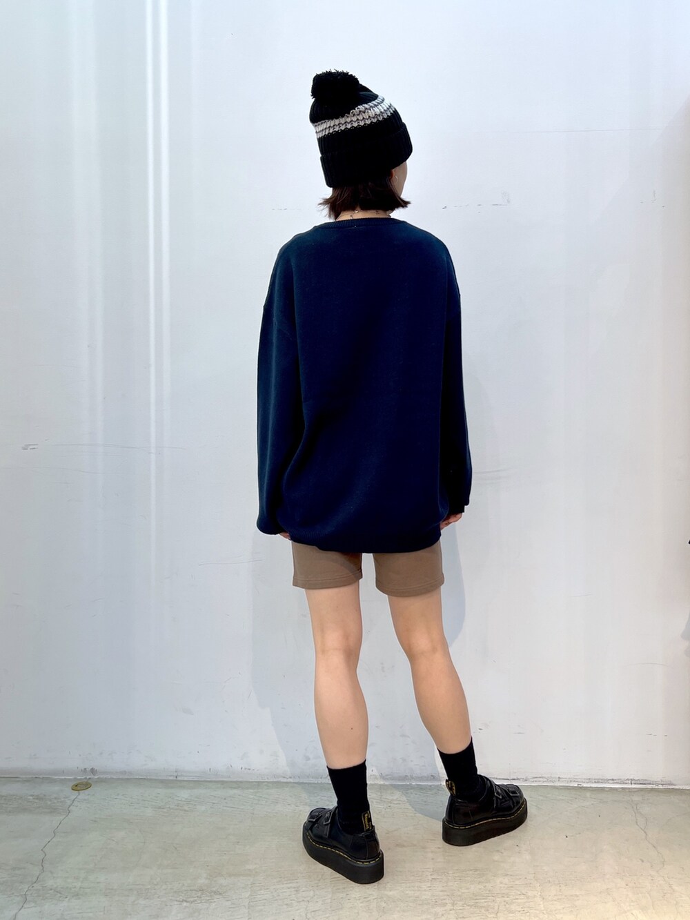 ブルー系のニット/セーター、ブラウン系のスウェットパンツ、ブラック系のニットキャップ/ビーニーを着用したレディースの秋コーディネートの2枚目の写真