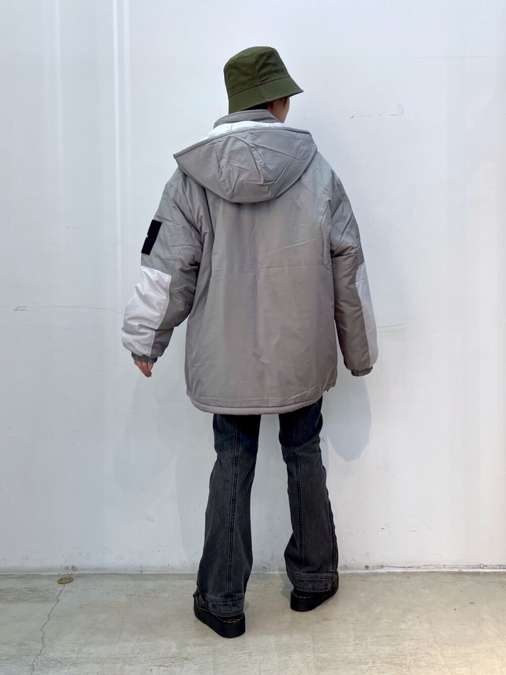 ブラック系のデニムパンツ、グレー系のマウンテンパーカー、ブラック系のニット/セーターを着用したレディースの秋コーディネートの2枚目の写真