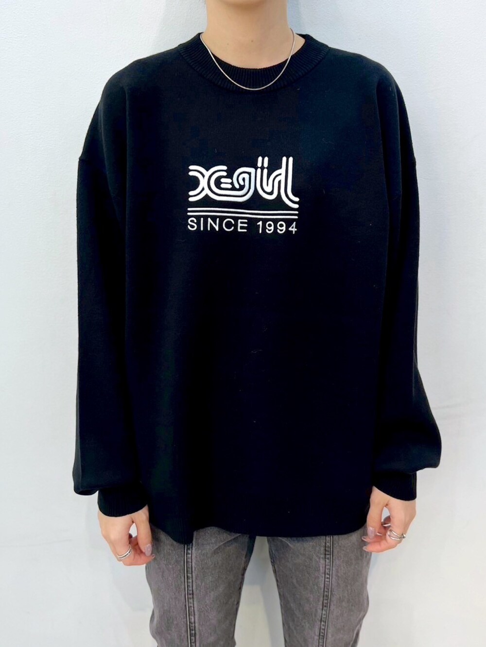 ブラック系のデニムパンツ、グレー系のマウンテンパーカー、ブラック系のニット/セーターを着用したレディースの秋コーディネートの5枚目の写真