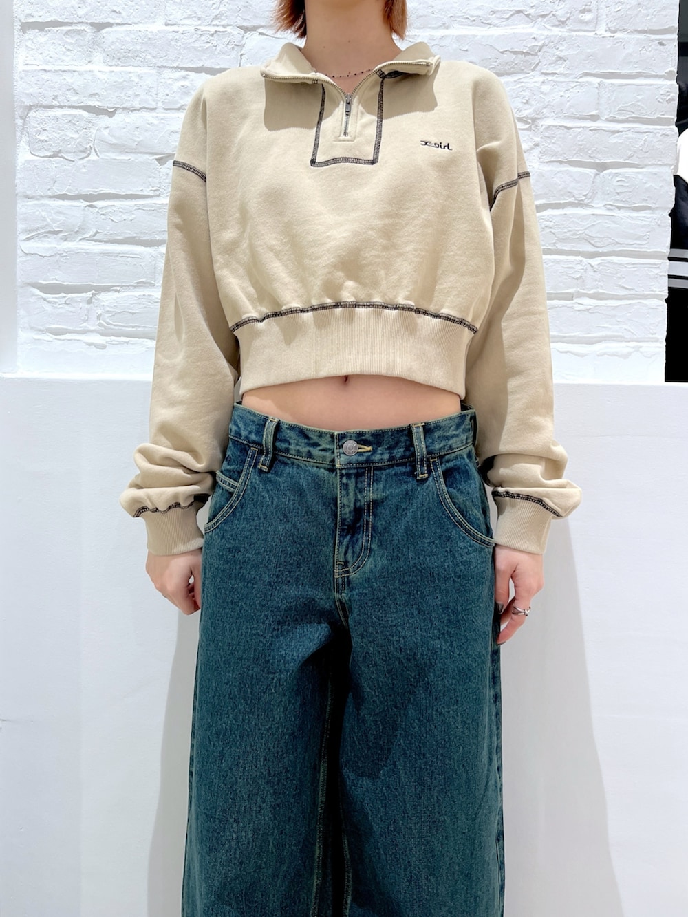 ブルー系のデニムパンツ、ベージュ系のスウェット、ブルー系のニットキャップ/ビーニーを着用したレディースの春コーディネートの3枚目の写真