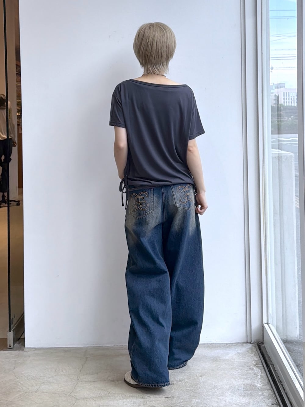 ブルー系のデニムパンツ、グレー系のTシャツ/カットソー、ピンク系のカードケースを着用したレディースの夏コーディネートの2枚目の写真