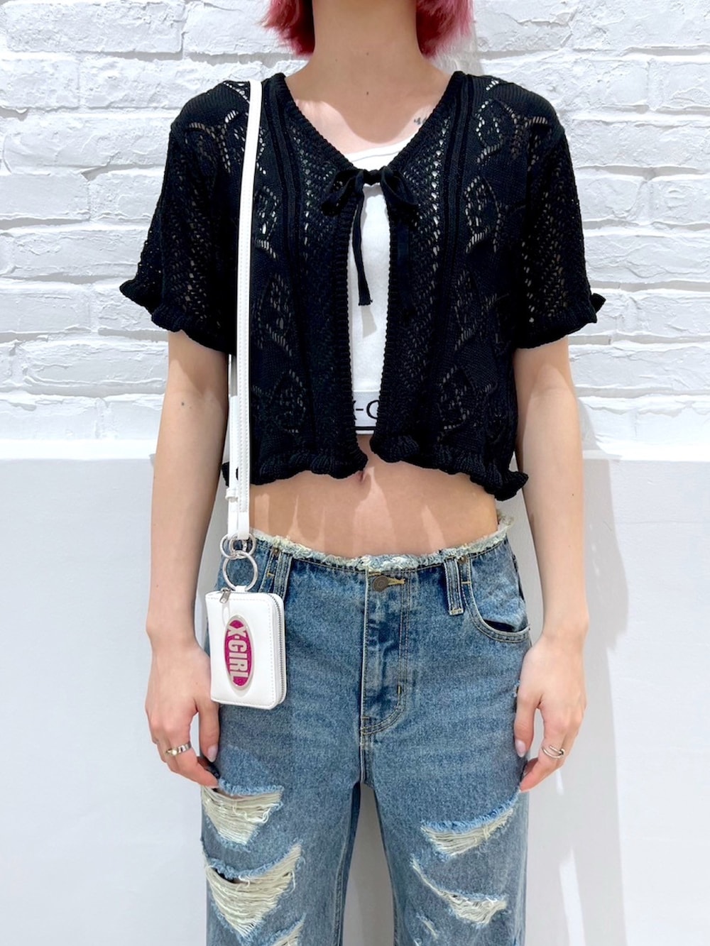 ホワイト系のTシャツ/カットソー、ブラック系のカーディガン/ボレロ、ブルー系のデニムパンツを着用したレディースの春コーディネートの3枚目の写真