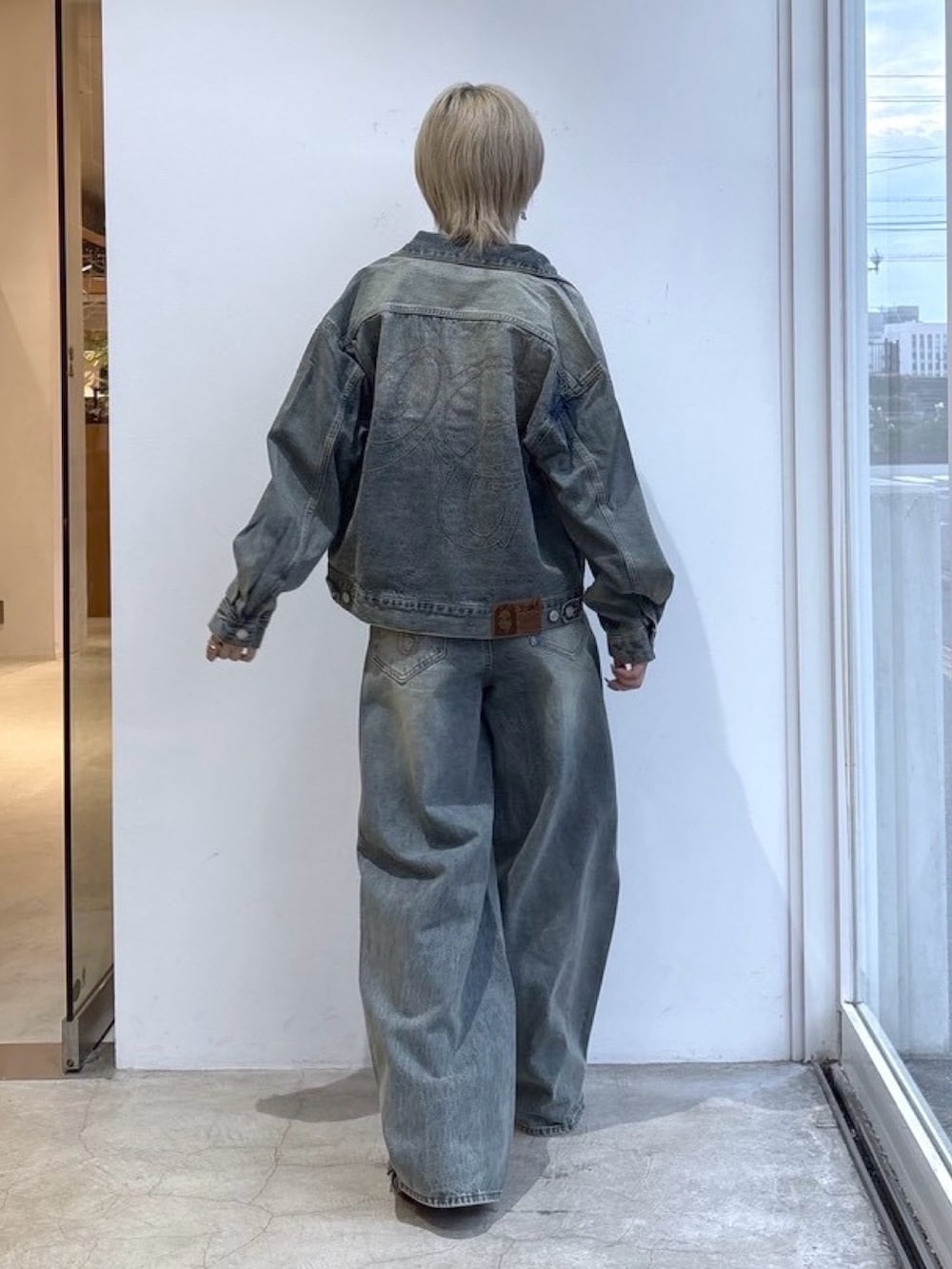 ブルー系のデニムパンツ、ブルー系のデニムジャケット、ベージュ系のTシャツ/カットソーを着用したレディースの夏コーディネートの2枚目の写真