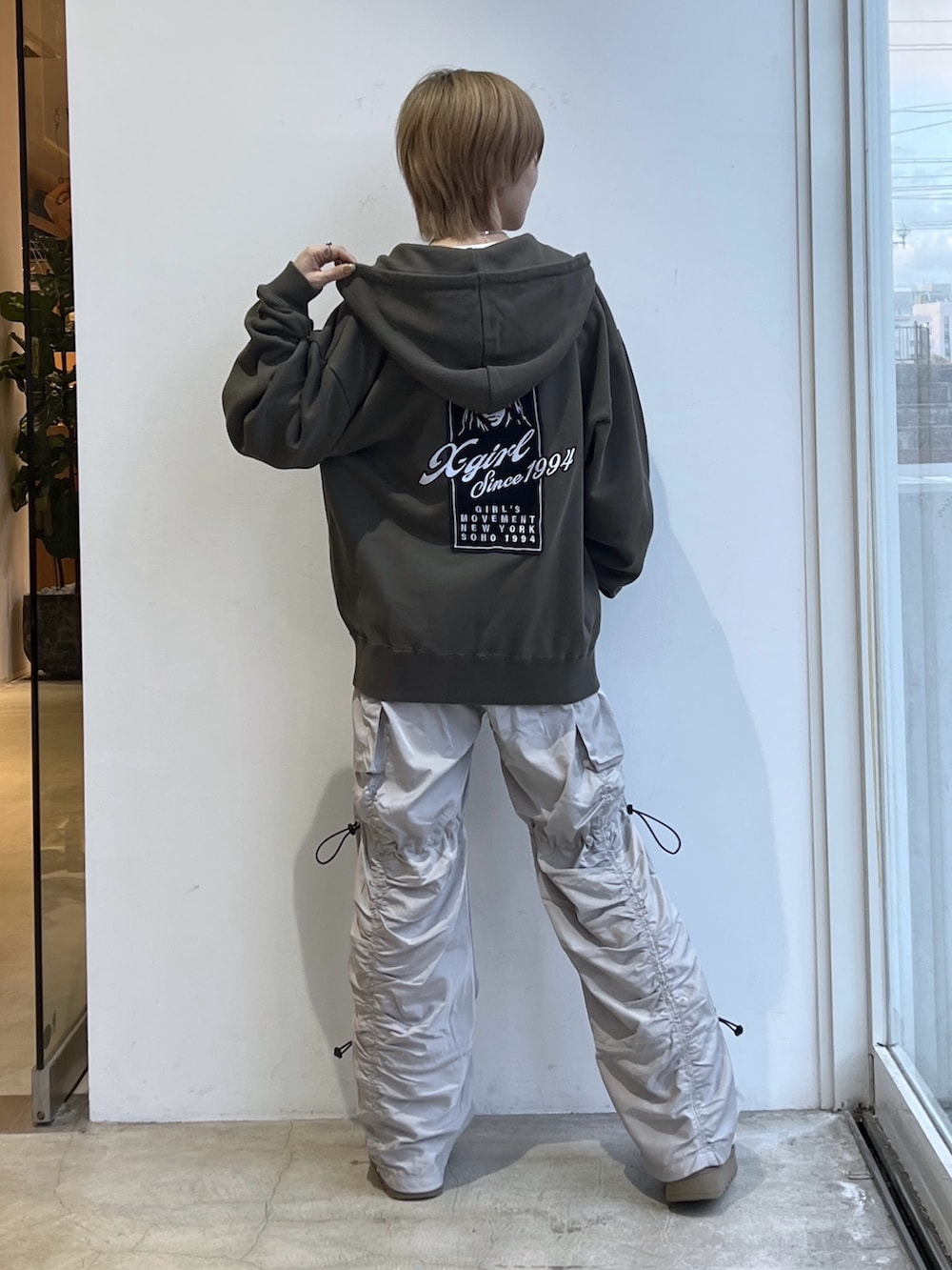 グレー系のその他パンツ、グリーン系のパーカー、ホワイト系のTシャツ/カットソーを着用したレディースの冬コーディネートの2枚目の写真