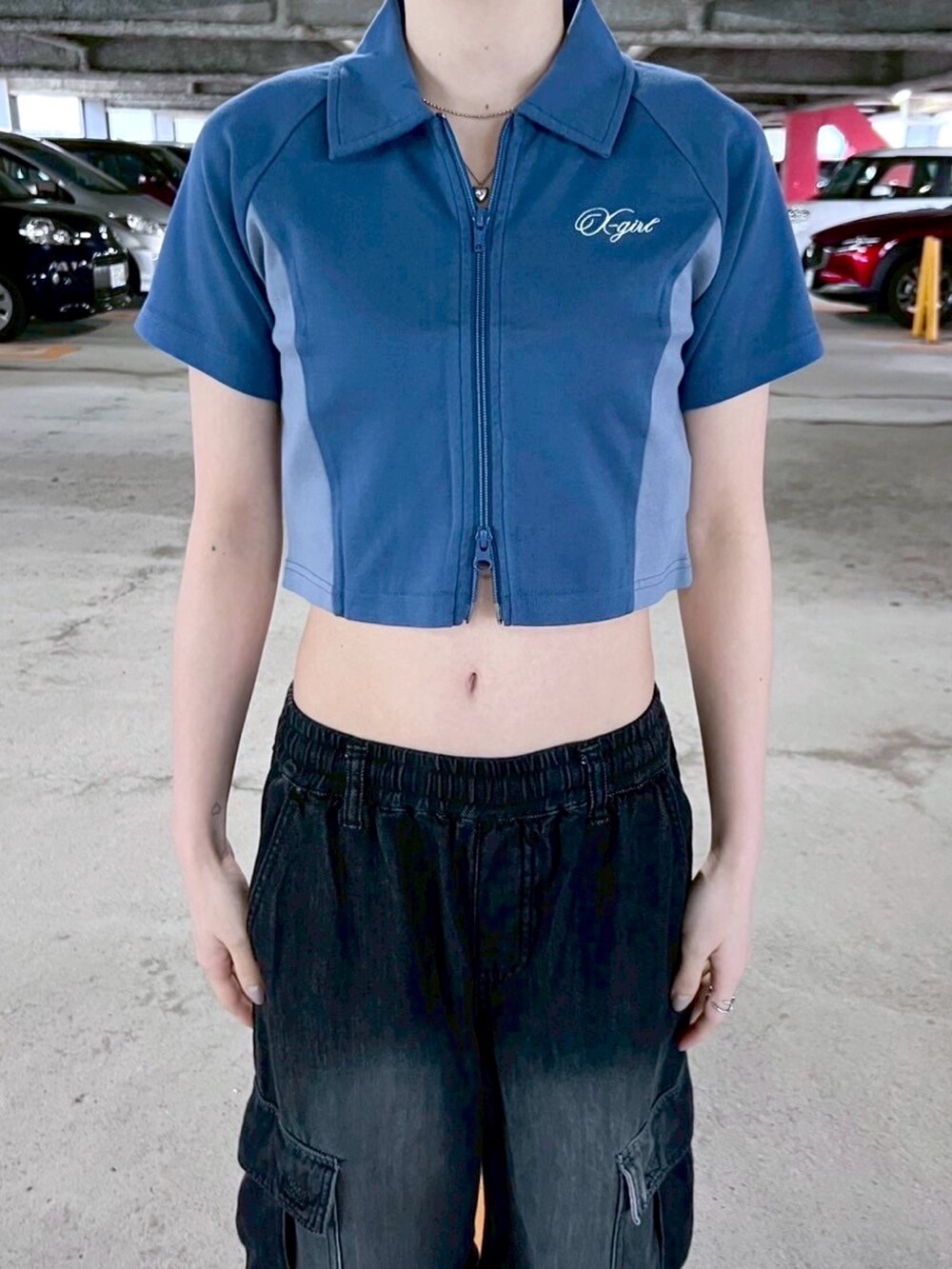 ブラック系のデニムパンツ、ブルー系のポロシャツ、ホワイト系のソックス/靴下を着用したレディースの春コーディネートの3枚目の写真