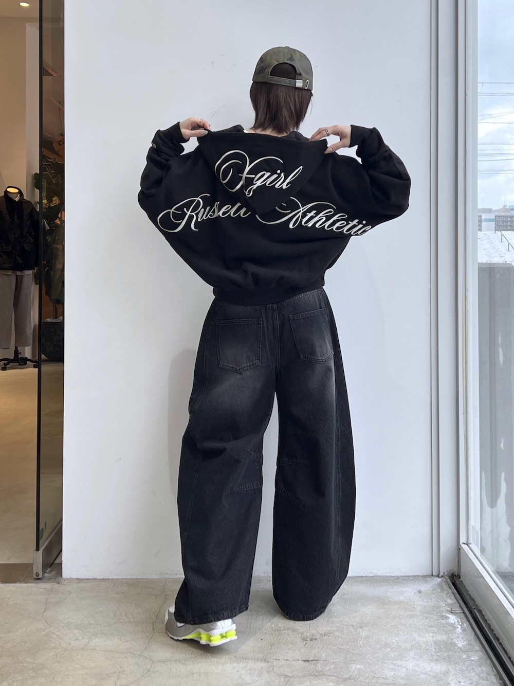 ブラック系のデニムパンツ、ブラック系のパーカー、ブラウン系のベルトを着用したレディースの冬コーディネートの2枚目の写真