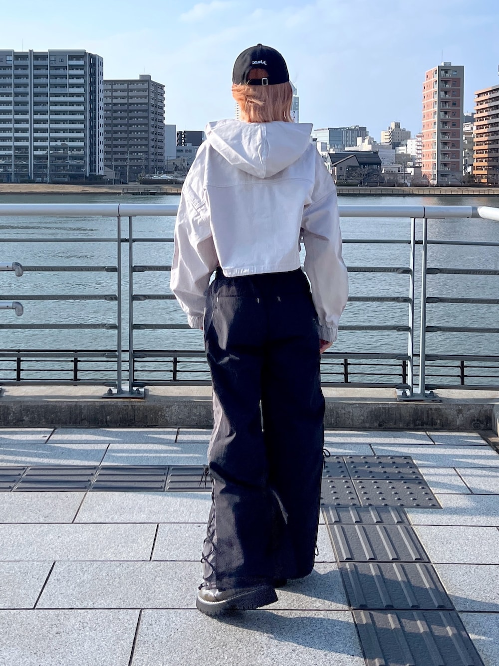 グレー系のブルゾン、ブラック系のその他パンツ、ブラック系のキャップを着用したレディースの春コーディネートの2枚目の写真