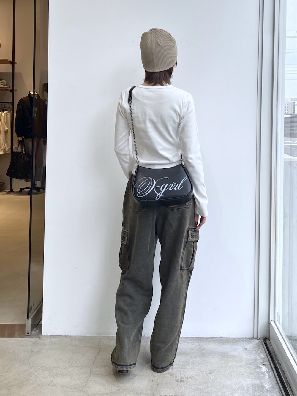 ブルー系のスウェットパンツ、ブラック系のショルダーバッグ、ホワイト系のTシャツ/カットソーを着用したレディースの冬コーディネートの2枚目の写真