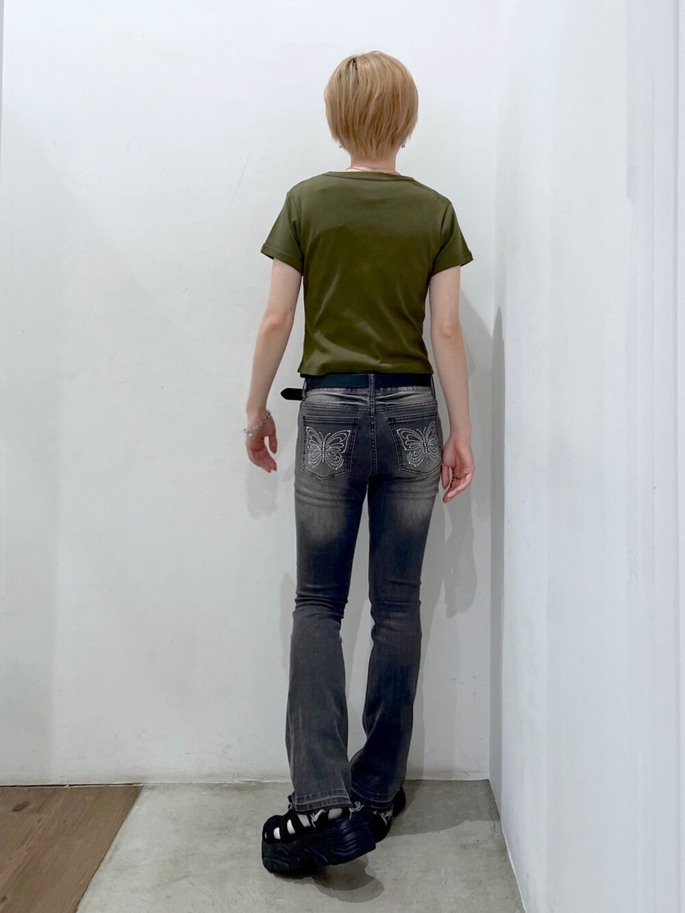 グレー系のデニムパンツ、グリーン系のTシャツ/カットソー、ブラック系のベルトを着用したレディースの夏コーディネートの2枚目の写真