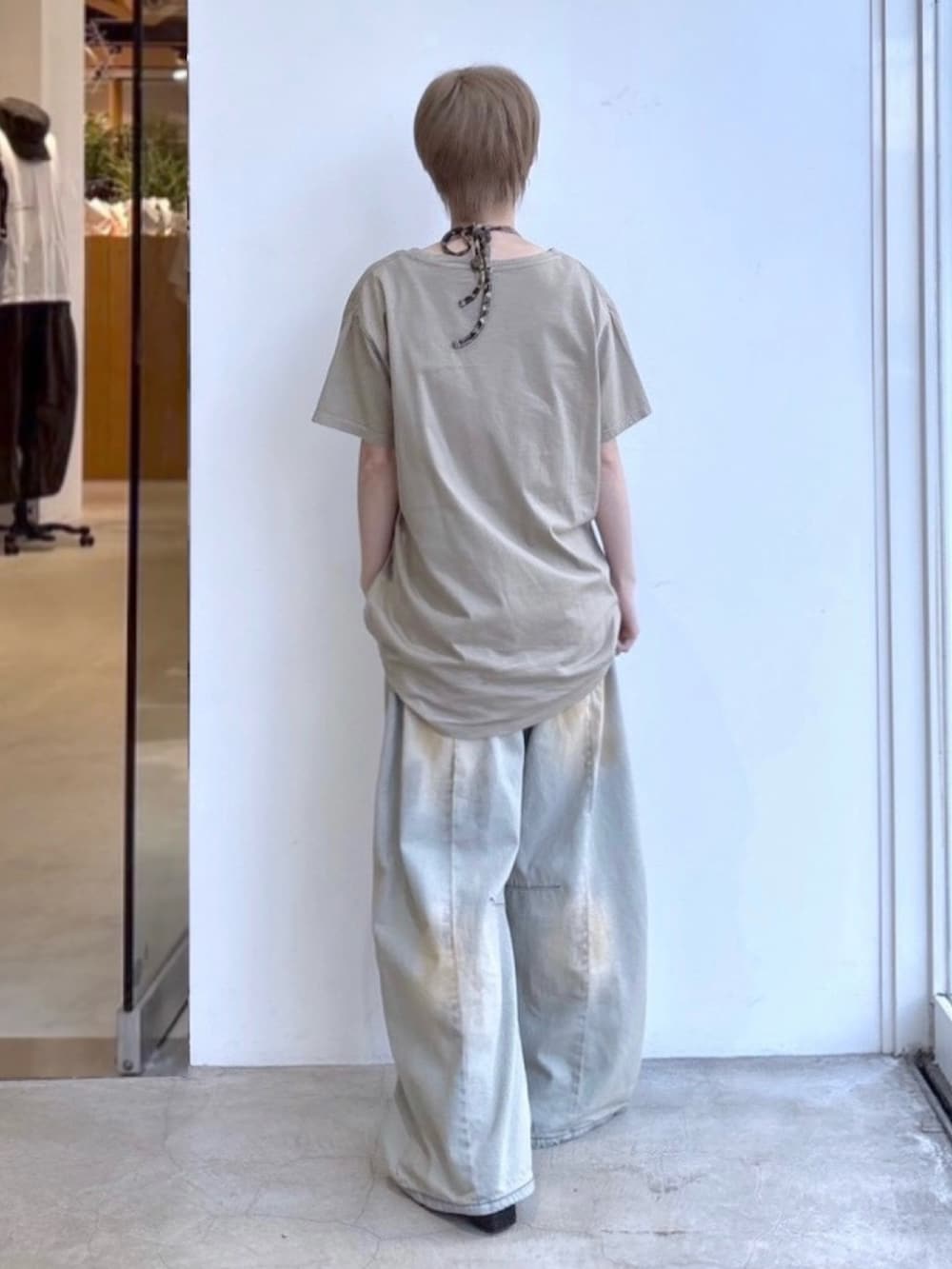 ブルー系のデニムパンツ、ベージュ系のワンピース、ベージュ系のキャミソールを着用したレディースの春コーディネートの2枚目の写真
