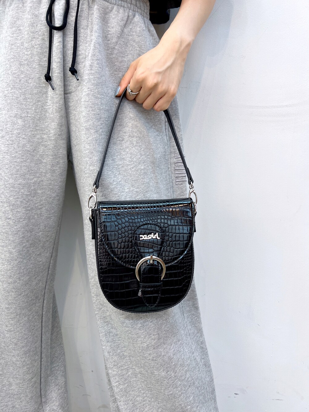 グレー系のスウェットパンツ、ブラック系のショルダーバッグ、ホワイト系のキャミソールを着用したレディースの夏コーディネートの5枚目の写真