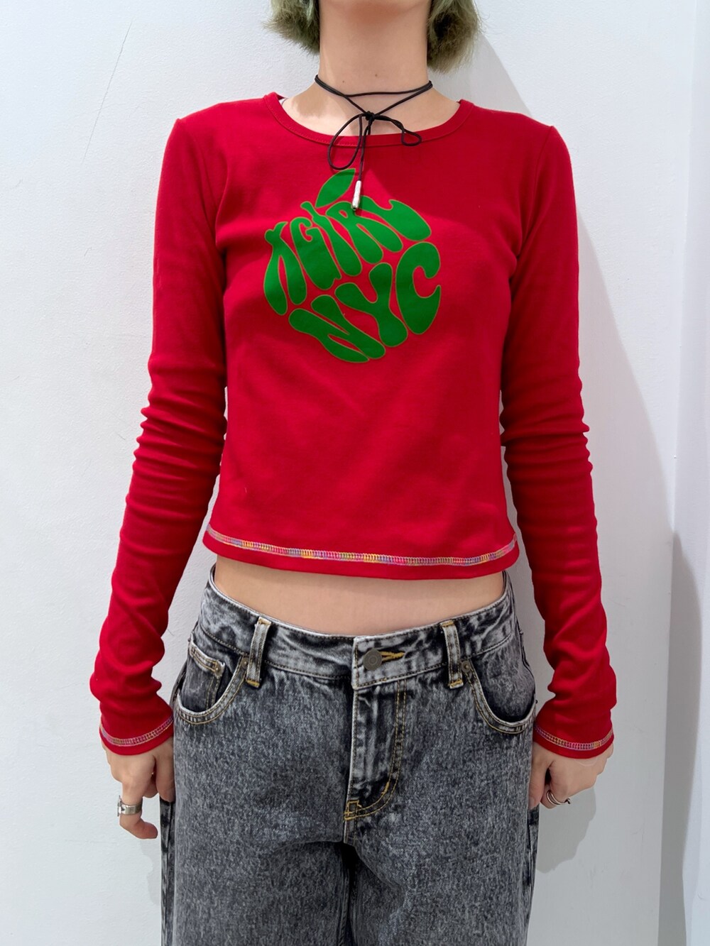 ブラック系のデニムパンツ、レッド系のTシャツ/カットソー、ブラック系のキャスケットを着用したレディースの秋コーディネートの3枚目の写真