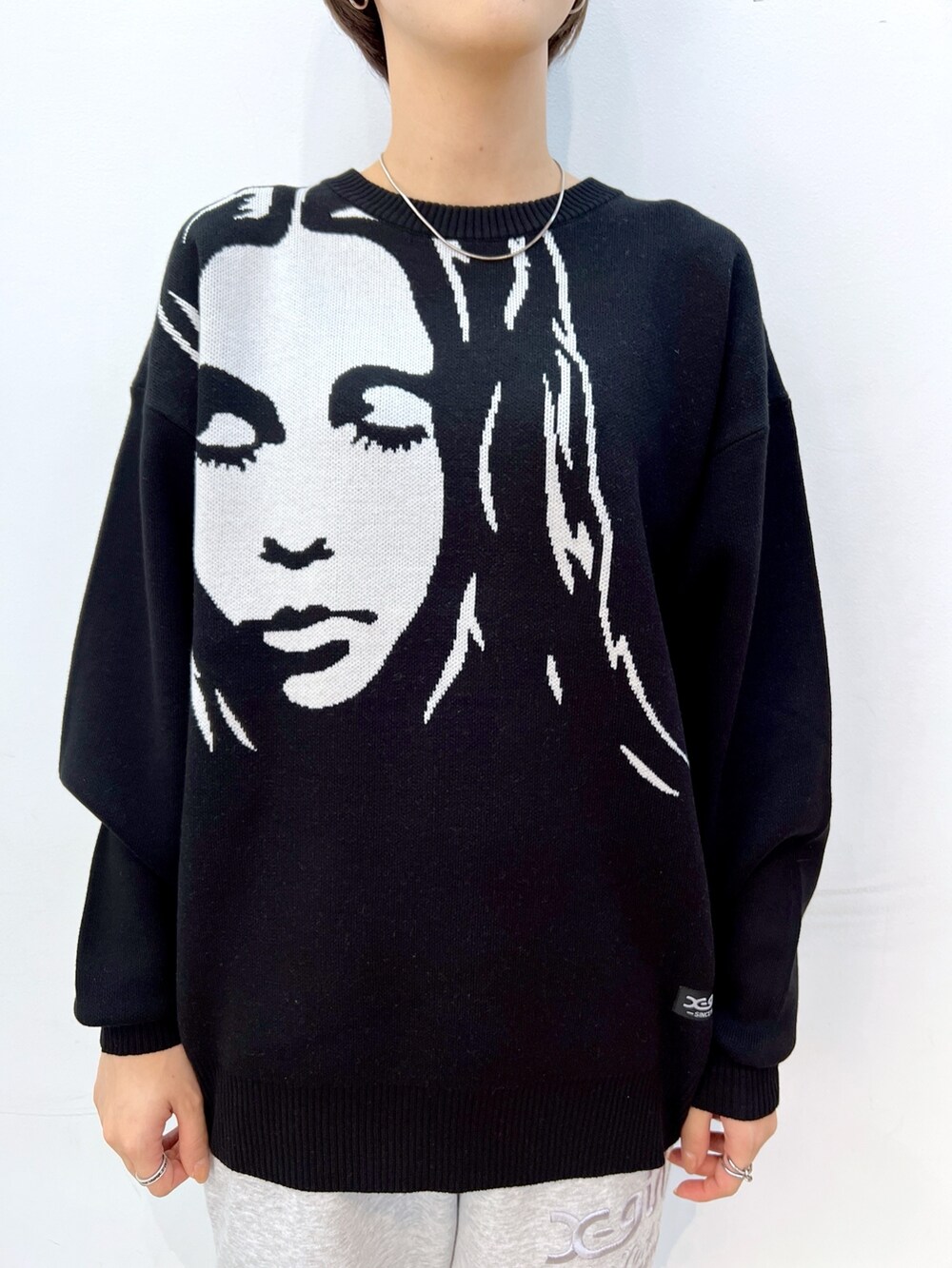 ブラック系のニット/セーター、グレー系のスウェットパンツ、ピンク系のショルダーバッグを着用したレディースの秋コーディネートの3枚目の写真