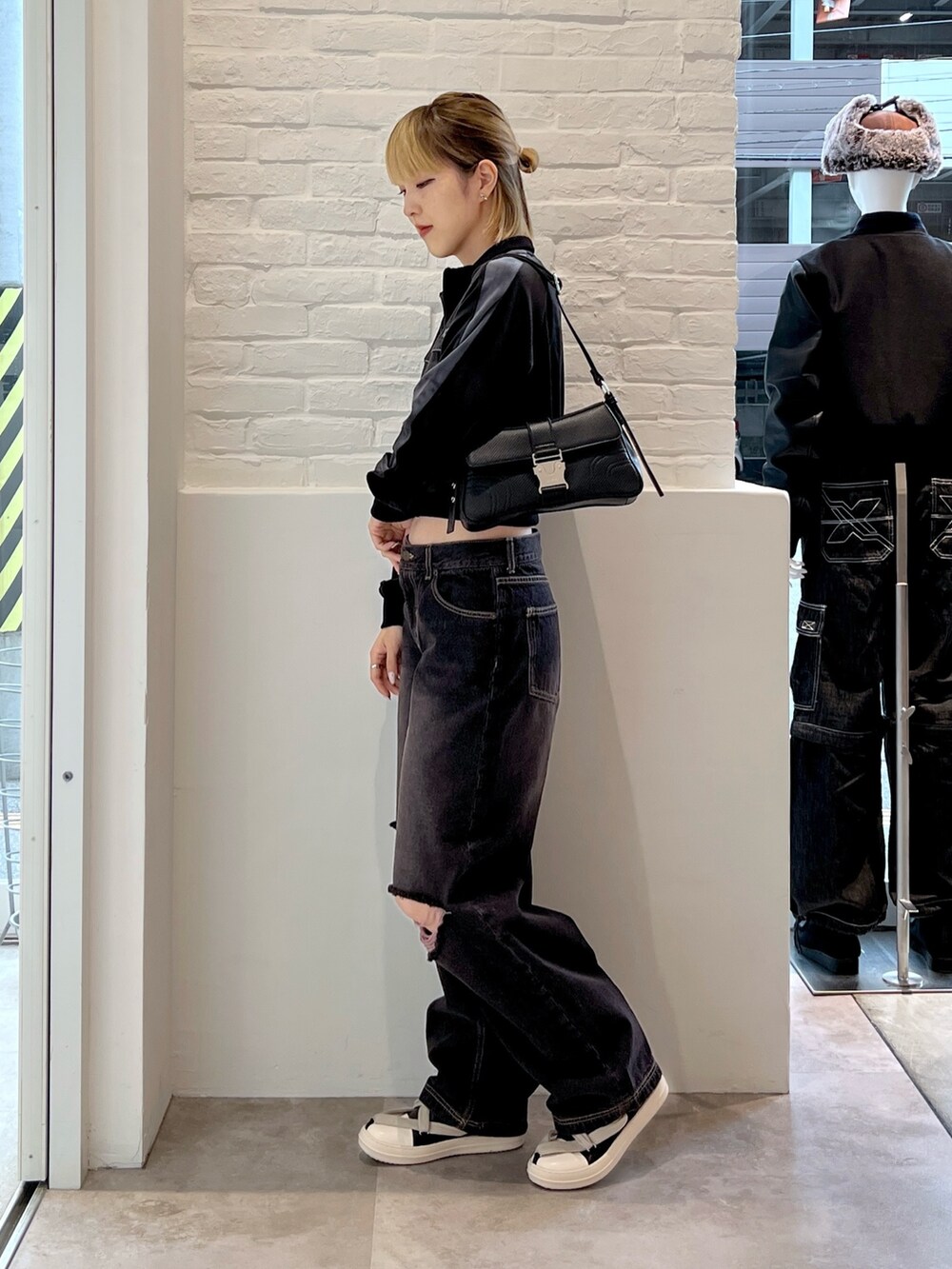 ブラック系のブルゾン、ブラック系のショルダーバッグ、ブラック系のデニムパンツを着用したレディースの秋コーディネートの2枚目の写真