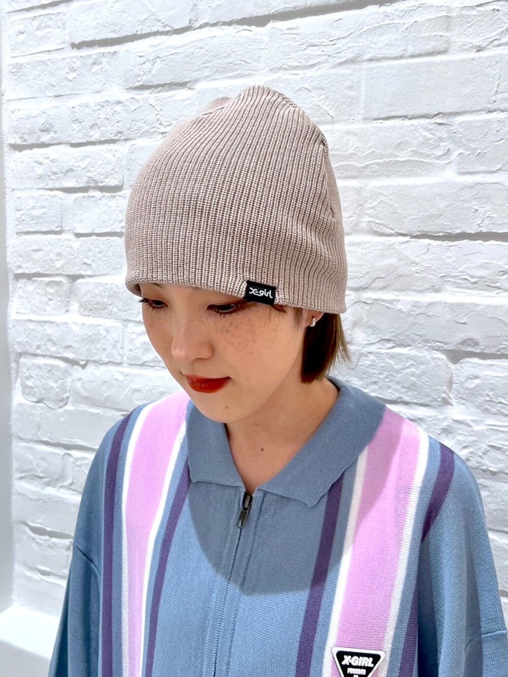 ブラック系のデニムパンツ、ブルー系のポロシャツ、ブラック系のニットキャップ/ビーニーを着用したレディースの春コーディネートの7枚目の写真