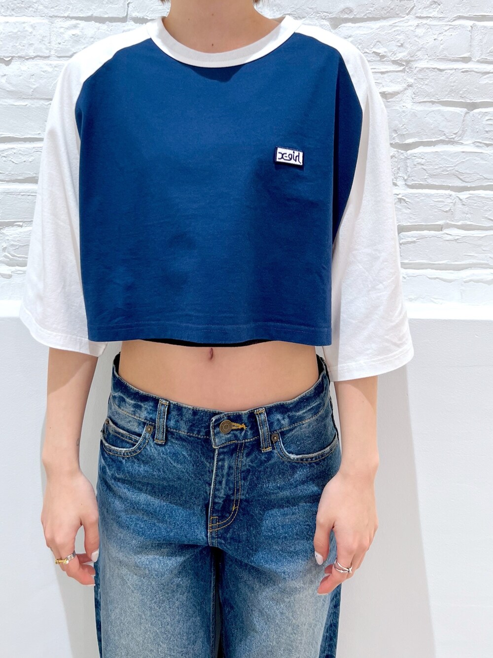 ブルー系のデニムパンツ、ブラック系のハンドバッグ、ブルー系のTシャツ/カットソーを着用したレディースの春コーディネートの3枚目の写真