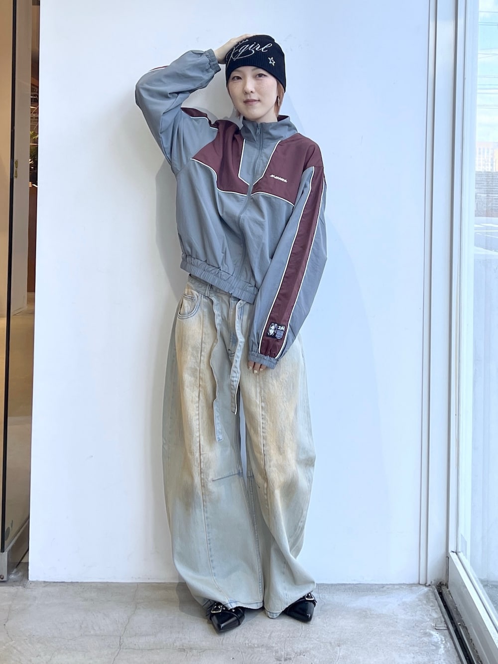 ブルー系のデニムパンツ、グレー系のナイロンジャケット、ブラック系のニットキャップ/ビーニーを着用したレディースの春コーディネートの2枚目の写真