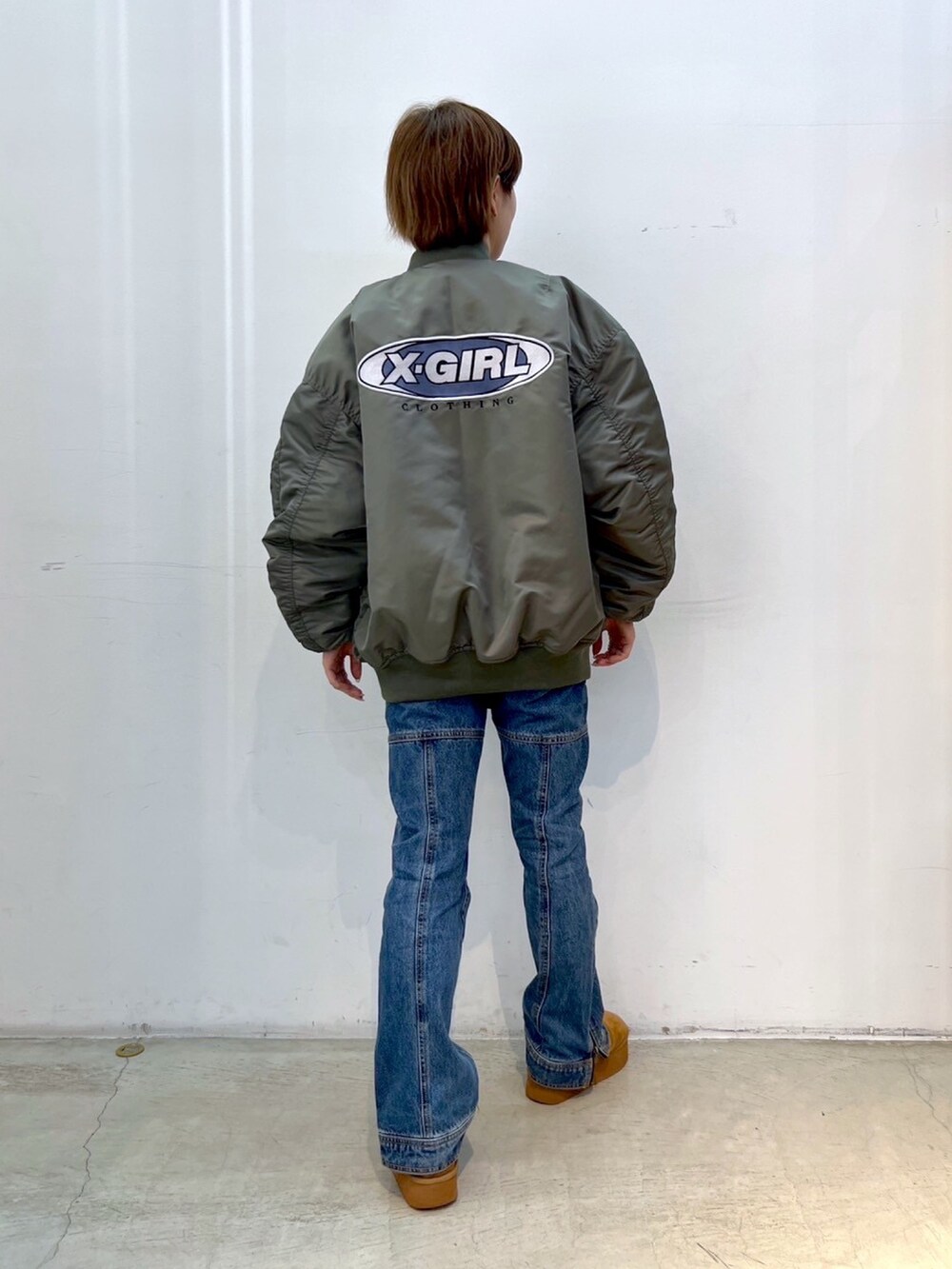 「x-girl、ストリート、ファッションを楽しもう、ビッグシルエット、ショート丈トップス、MA-1、ジャケット、ジャケットスタイル、デニムパンツ、パンツスタイル、ムートンブーツ、冬コーデ、マイベストコーデ2023」｜「X-girlのSIDE ZIP DENIM PANTS（デニムパンツ、ブルー系）」を使った、小島えみるさん（レディース・165cm）の秋コーディネートの2枚目の写真