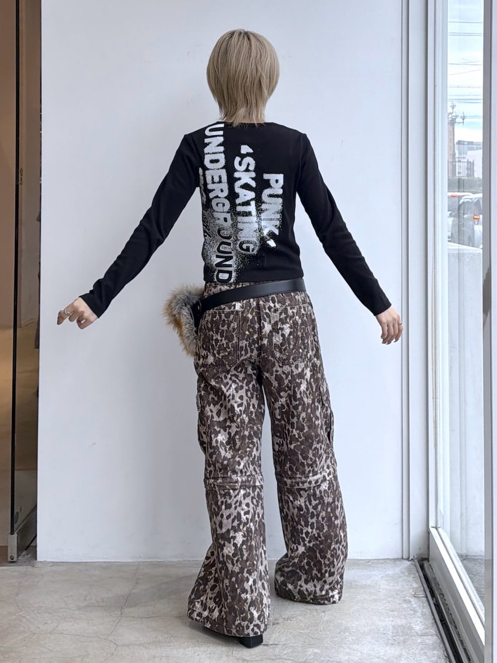 ベージュ系のカーゴパンツ、ブラック系のTシャツ/カットソー、ブラック系のベルトを着用したレディースの秋コーディネートの2枚目の写真