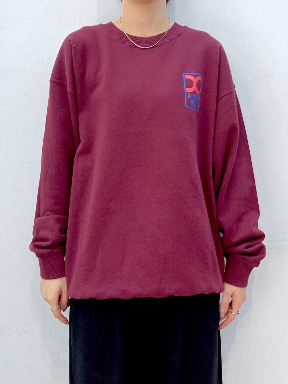 レッド系のスウェット、ブラック系のスウェットパンツ、ブラック系のスニーカーを着用したレディースの秋コーディネートの3枚目の写真