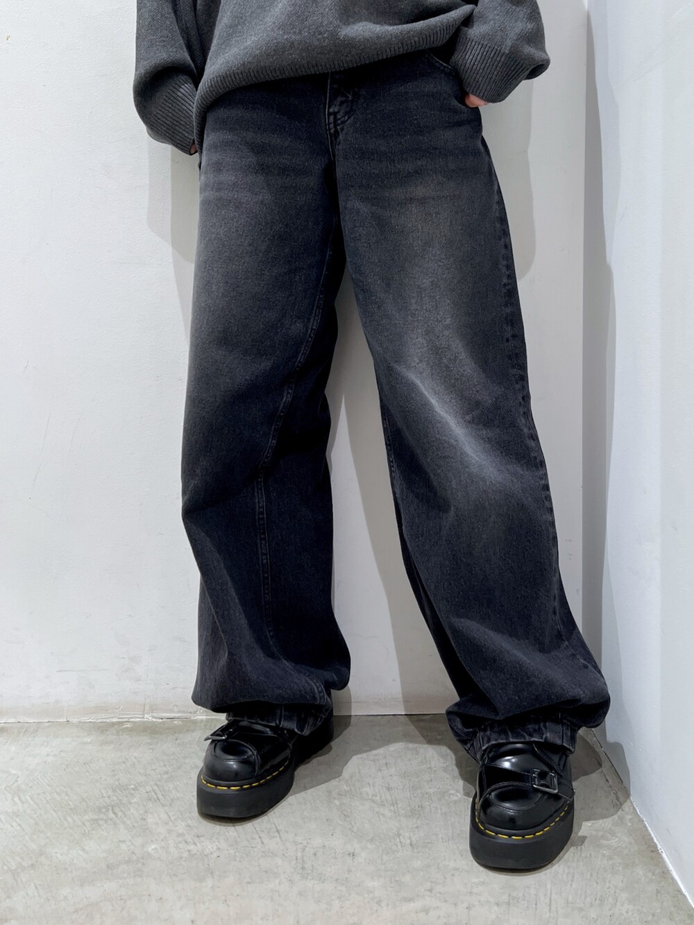 ホワイト系のショルダーバッグ、ブラック系のデニムパンツ、グレー系のニット/セーターを着用したレディースの秋コーディネートの6枚目の写真