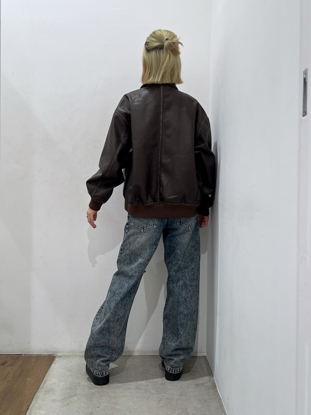 ブルー系のデニムパンツ、ブラウン系のブルゾン、その他のTシャツ/カットソーを着用したレディースの秋コーディネートの2枚目の写真