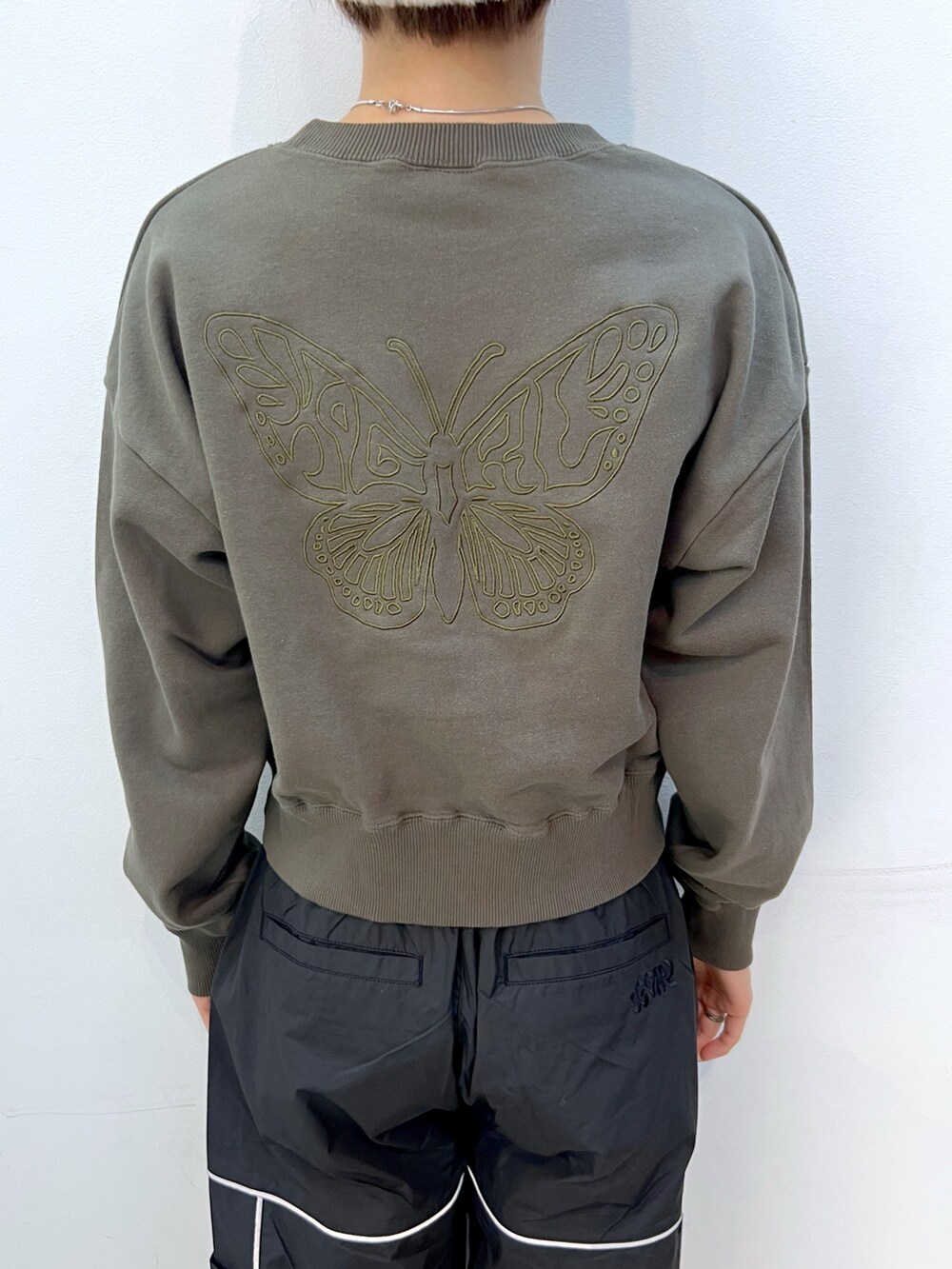 ブラック系のその他パンツ、グリーン系のスウェット、ホワイト系のハットを着用したレディースの秋コーディネートの4枚目の写真