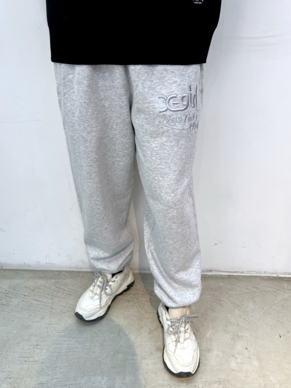 ブラック系のニット/セーター、グレー系のスウェットパンツ、ピンク系のショルダーバッグを着用したレディースの秋コーディネートの4枚目の写真