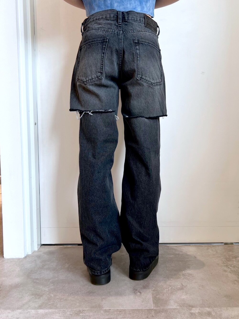 ブラック系のデニムパンツ、ブルー系のパーカー、その他のタンクトップを着用したレディースの春コーディネートの5枚目の写真