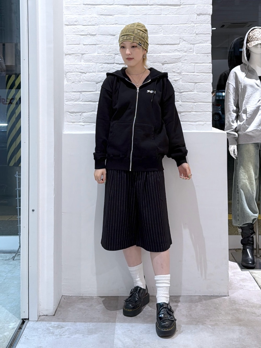グレー系のその他パンツ、ブラック系のパーカー、グリーン系のニットキャップ/ビーニーを着用したレディースの秋コーディネートの2枚目の写真