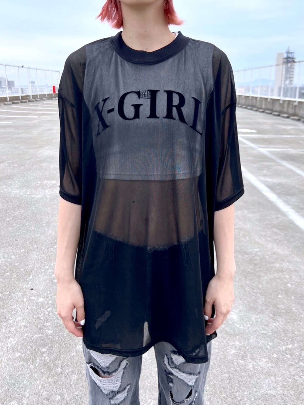 ブラック系のデニムパンツ、ブラック系のTシャツ/カットソー、ホワイト系のタンクトップを着用したレディースの夏コーディネートの3枚目の写真
