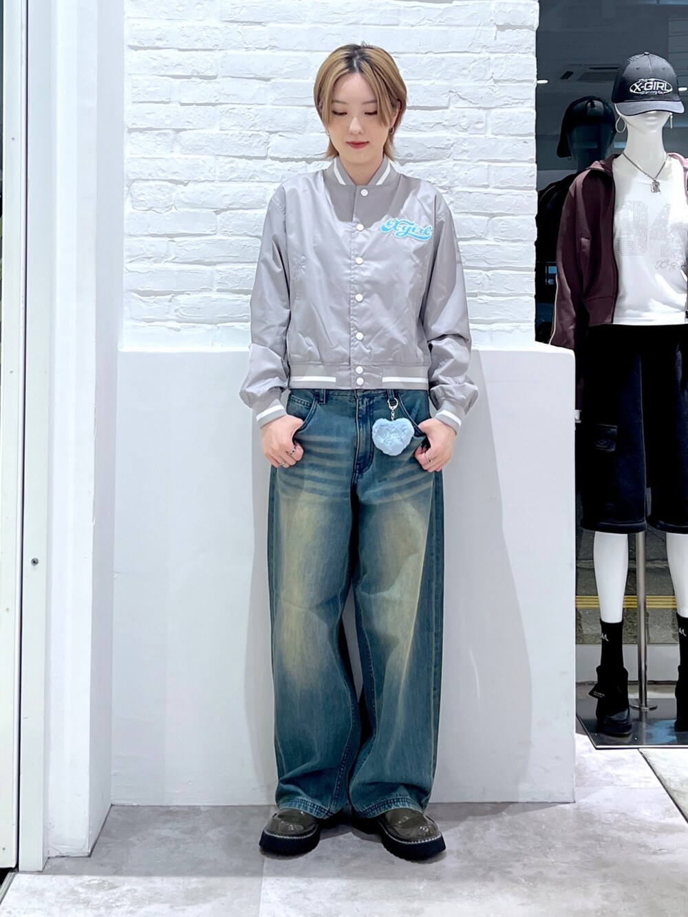 ブルー系のデニムパンツ、グレー系のスタジャンを着用したレディースの秋コーディネートの2枚目の写真