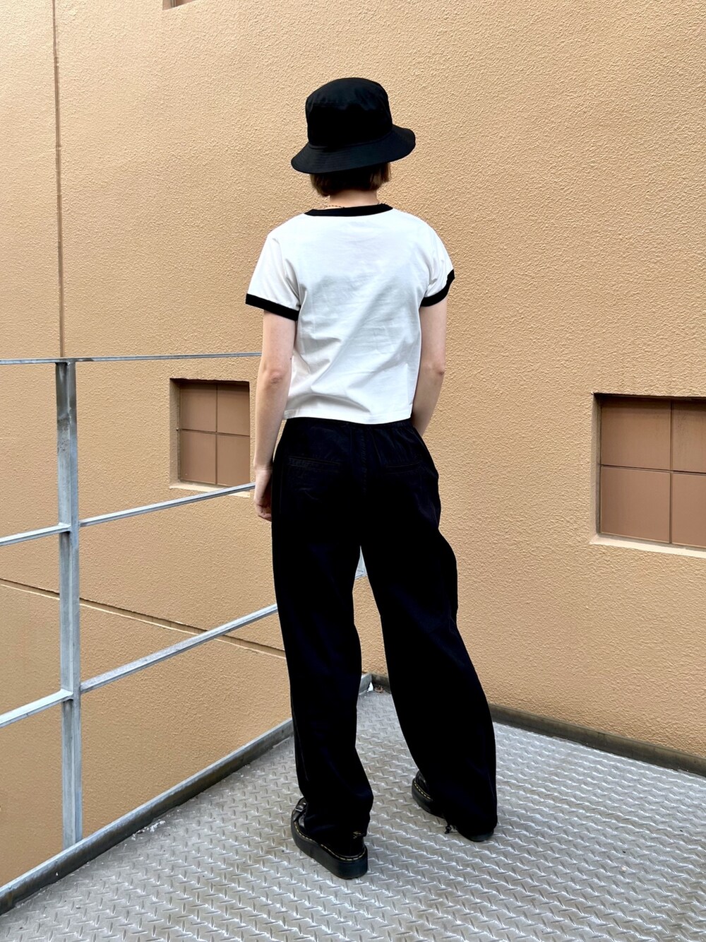 ブラック系のその他パンツ、ホワイト系のTシャツ/カットソー、ブラック系のハットを着用したレディースの春コーディネートの2枚目の写真