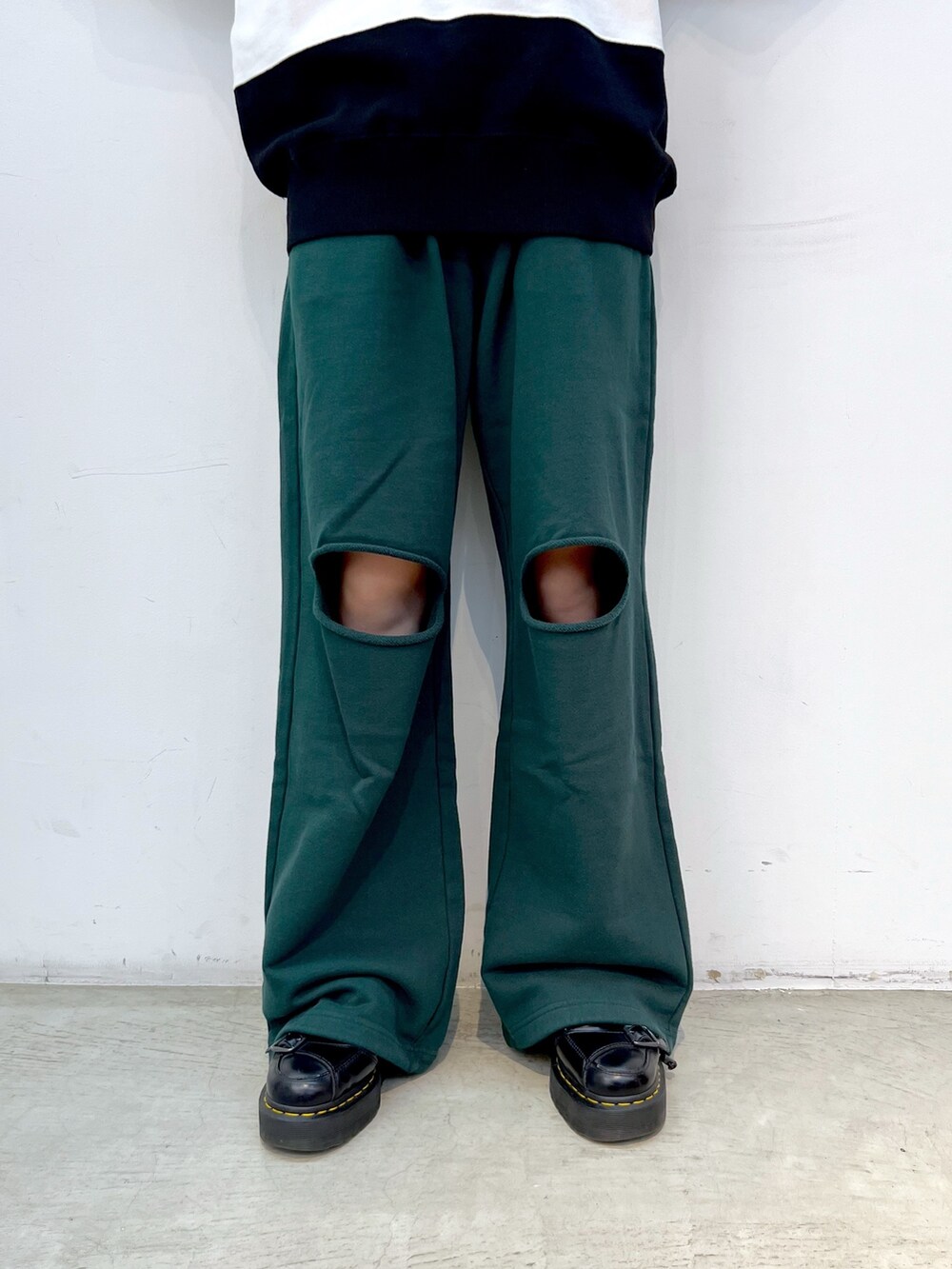 グリーン系のスウェットパンツ、ホワイト系のスウェット、ブラック系のキャップを着用したレディースの秋コーディネートの4枚目の写真